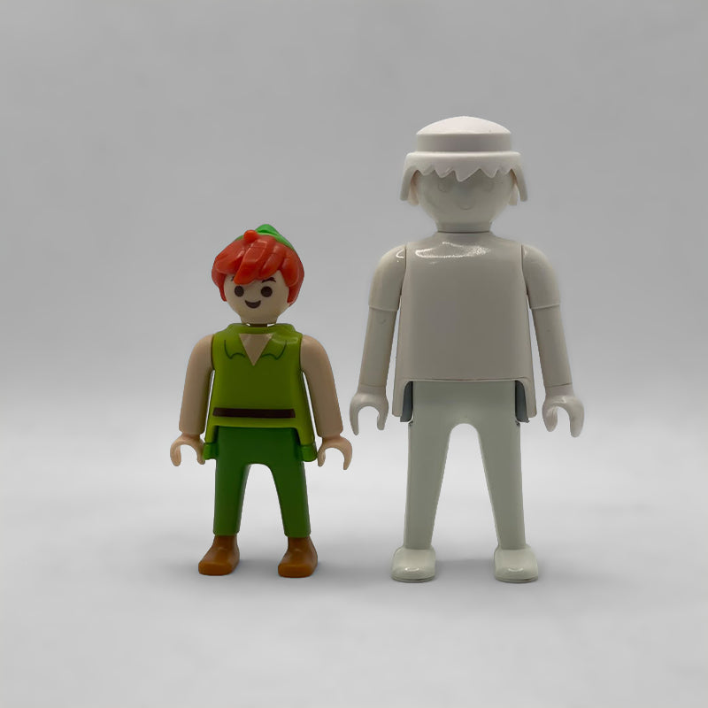 Comparativa de tamaño: minifigura Peter Pan FCO1001 junto a una figura Playmobil estándar blanca, no incluida