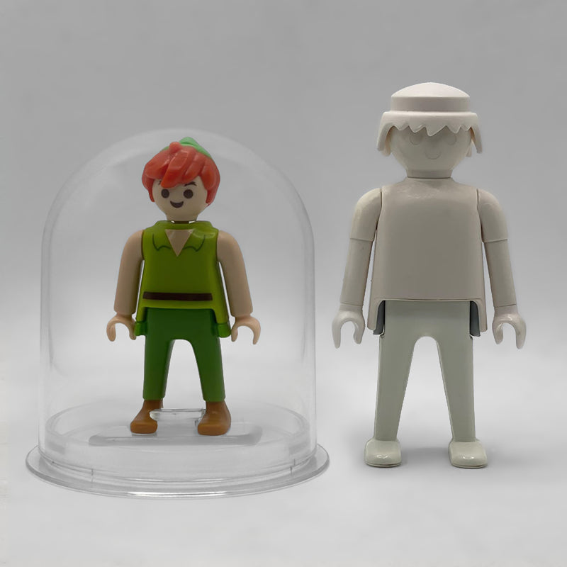 Comparativa de tamaño: Peter Pan FCO1011 dentro de su urna expositora junto a una figura Playmobil estándar blanca, que no está incluida
