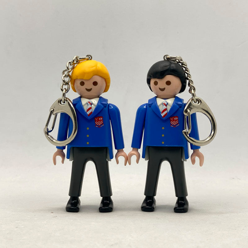 Pareja de llaveros Playmobil del centenario del St Aloysius College con blazer azul, corbata de rayas y escudo rojo