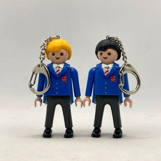 Pareja de llaveros Playmobil del centenario del St Aloysius College con blazer azul, corbata de rayas y escudo rojo