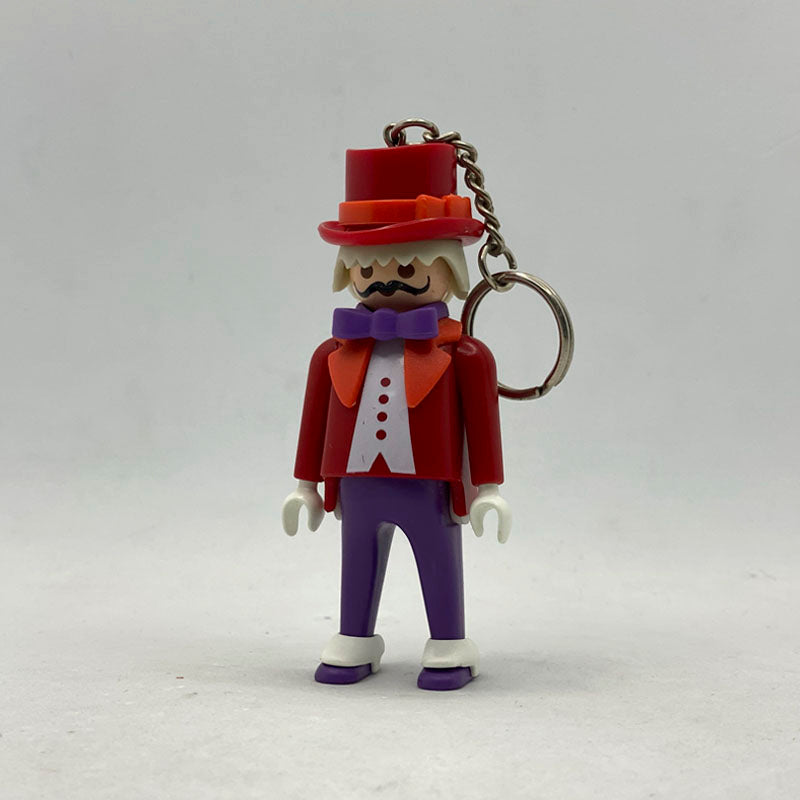 Llavero Playmobil Director de Circo con chistera roja, frac rojo, pajarita morada y bigote negro