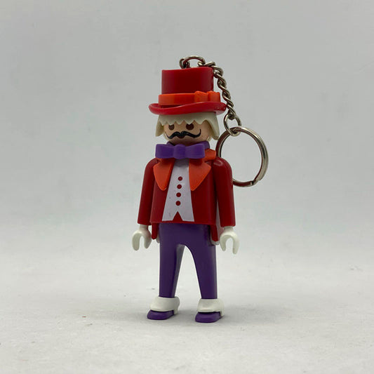 Llavero Playmobil Director de Circo con chistera roja, frac rojo, pajarita morada y bigote negro