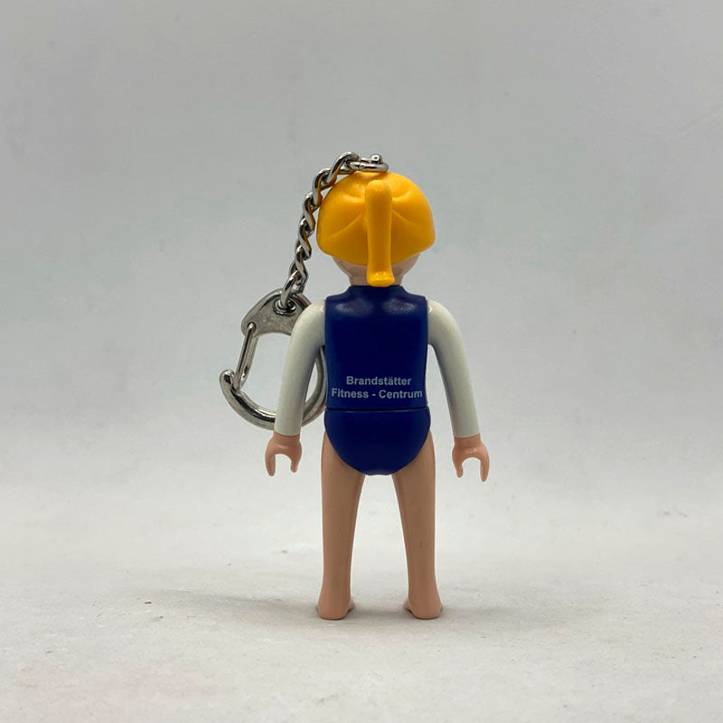 Llavero Playmobil Gimnasta por detrás, con la serigrafía Brandstätter Fitness-Centrum en la espalda