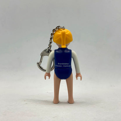 Llavero Playmobil Gimnasta por detrás, con la serigrafía Brandstätter Fitness-Centrum en la espalda