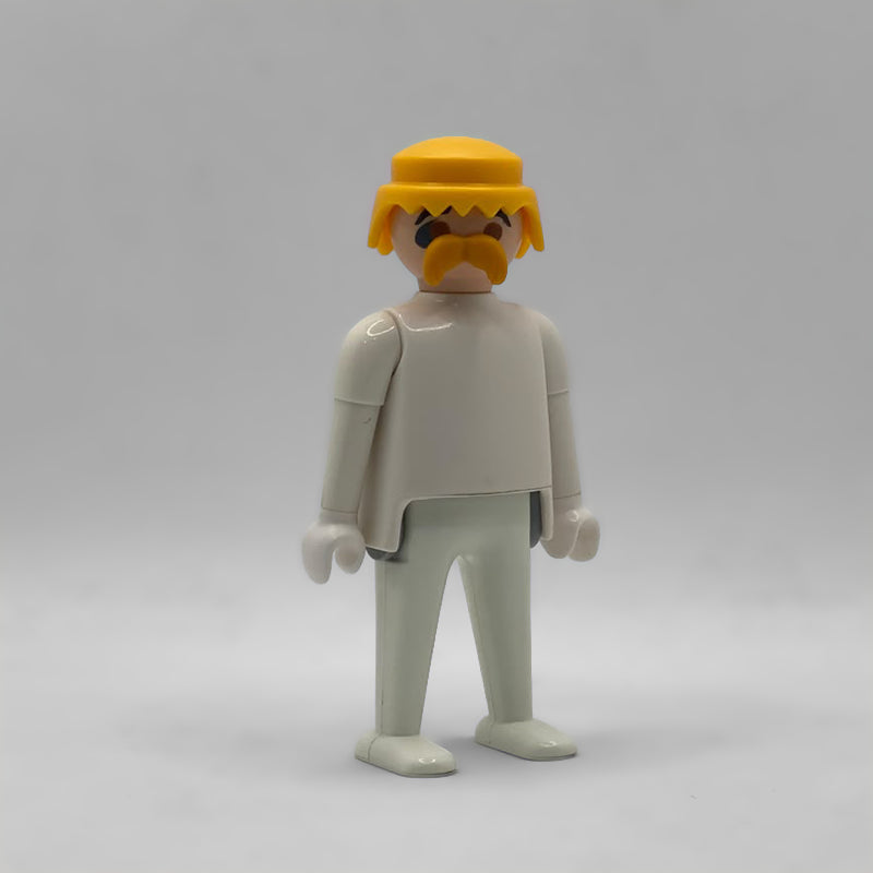 Playmobil cabeza completa con bigote rubia CAB142 montada sobre un cuerpo blanco: peluca amarilla con flequillo en pico, bigote rubio y cejas negras