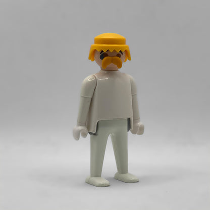 Playmobil cabeza completa con bigote rubia CAB142 montada sobre un cuerpo blanco: peluca amarilla con flequillo en pico, bigote rubio y cejas negras
