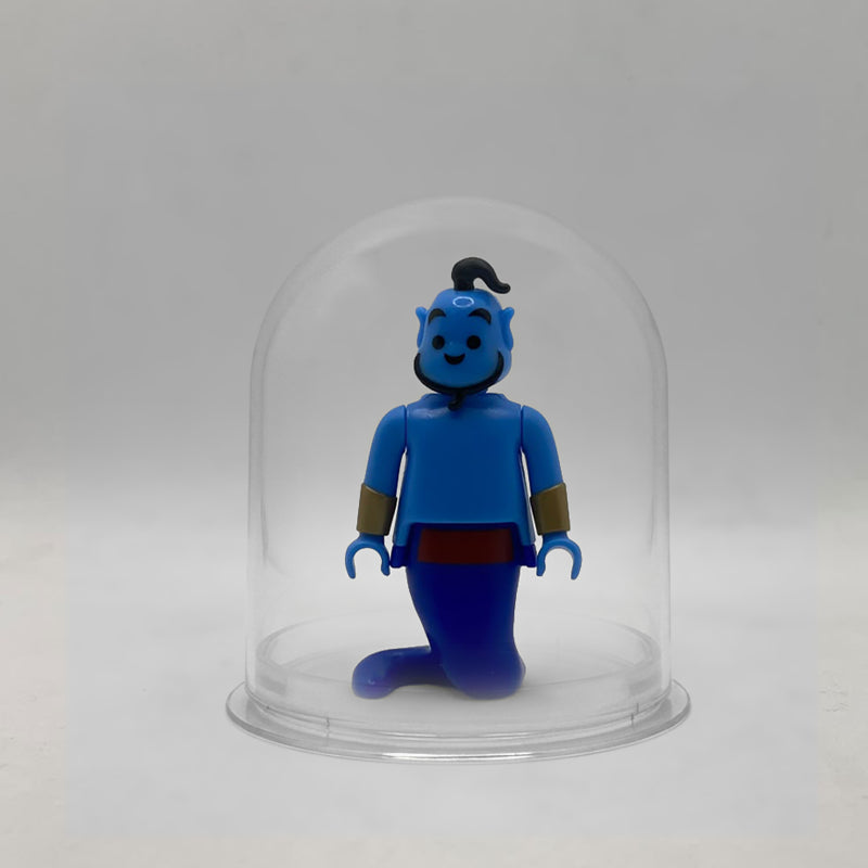 Minifigura Playmobil del Genio de la lámpara de Aladín, con cola de humo azul, fajín rojo y coleta negra, de pie dentro de la urna expositora transparente sin peana, colección Disney Kinder FCO1006