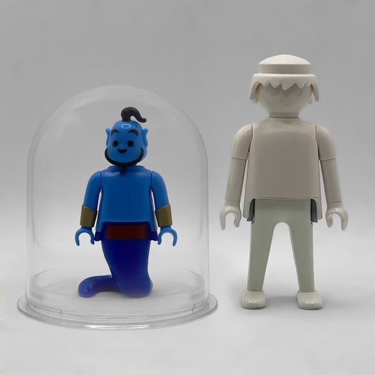 Comparativa de tamaño: el Genio FCO1006 dentro de su urna expositora junto a una figura Playmobil estándar blanca, que no está incluida