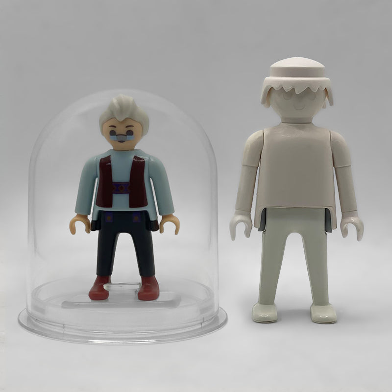 Comparativa de tamaño: Geppetto FCO1007 dentro de su urna expositora junto a una figura Playmobil estándar blanca, que no está incluida