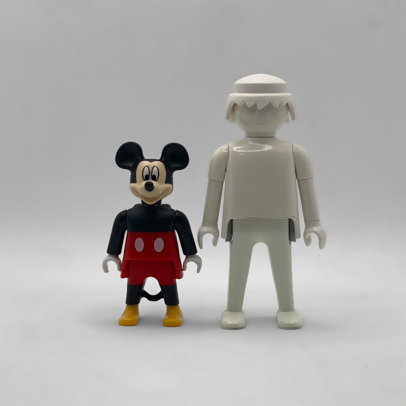 Comparativa de tamaño: minifigura Mickey Mouse FCO998 junto a una figura Playmobil estándar blanca, no incluida