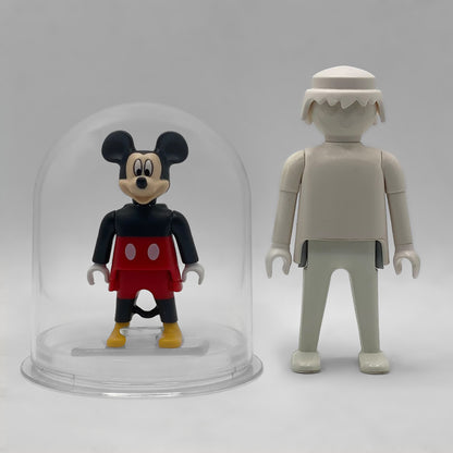Comparativa de tamaño: Mickey Mouse FCO1009 dentro de su urna expositora junto a una figura Playmobil estándar blanca, que no está incluida