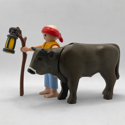 Playmobil Pastor con Buey FCO5031: figura con pañuelo rojo, chaleco de lana y farol en un bastón, junto al buey pardo oscuro