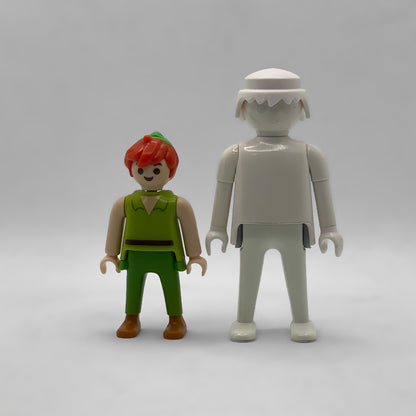 Comparativa de tamaño: minifigura Peter Pan FCO1001 junto a una figura Playmobil estándar blanca, no incluida