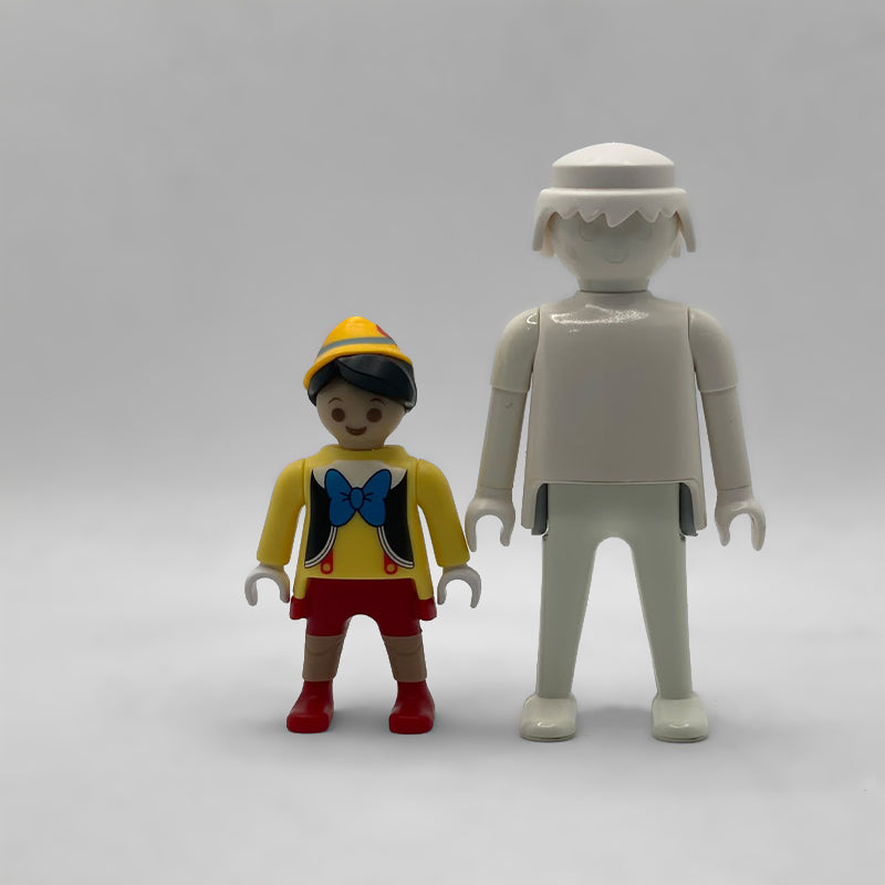 Comparativa de tamaño: minifigura Pinocho FCO1002 junto a una figura Playmobil estándar blanca, no incluida